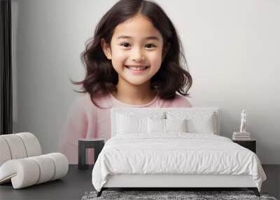 Portrait of a cute asian little girl smiling over white background Wall mural