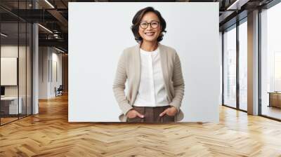 Portrait of a smiling mature businesswoman in eyeglasses standing isolated over white background Wall mural