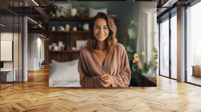 Portrait of smiling young woman in bathrobe looking at camera at home Wall mural