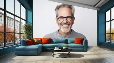 Serenely smiling middle-aged man with gray hair and beard in wool sweater on white background. Wall mural