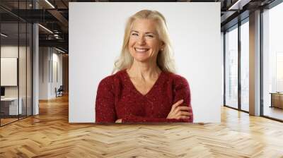 Confident, happy, smiling mature woman in red sweater, in 50s, isolated on solid white background with copy space. Wall mural