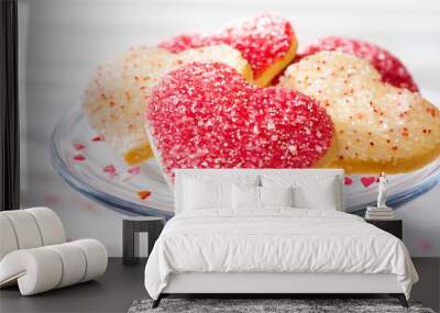 Heart shaped sugar cookies with white, pink, and red sugar sprinkles on a glass tray Wall mural