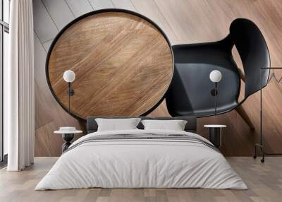 Round wooden table and black chair indoors top view Wall mural