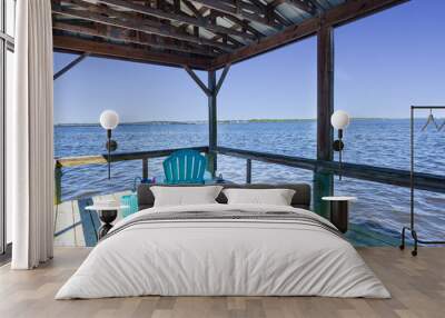 Teal chair on a dock overlooking the river Wall mural