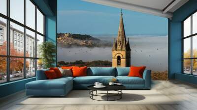 view of church tower at Bonnieux hiitop village in  provence  France with Lacoste in the background misty autumn morning seen from the luberon mountain . Wall mural