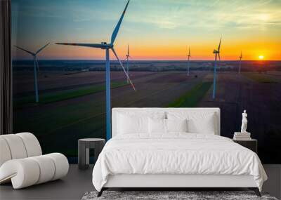 Wind turbines in a field just before sunrise, representing the concept of renewable energy and sustainability. Wall mural