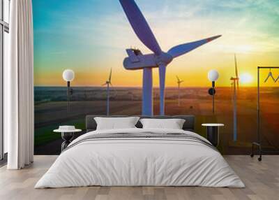 Wind turbines in a field just before sunrise, representing the concept of renewable energy and sustainability. Wall mural