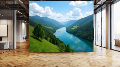 winding river surrounded by lush green hills and forests under a blue sky Wall mural