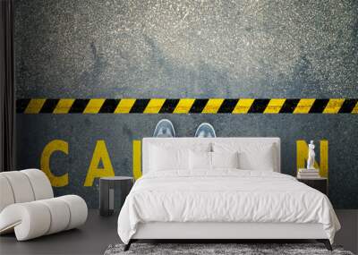 Top view of a man stands on industrial striped asphalt floor with warning yellow black caution pattern. Wall mural