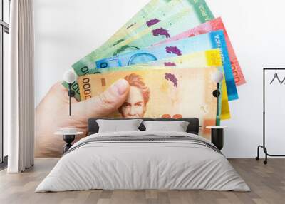 Costa Rican money, Colones, Banknotes spread out in a fan and held in a male hand, White background Wall mural