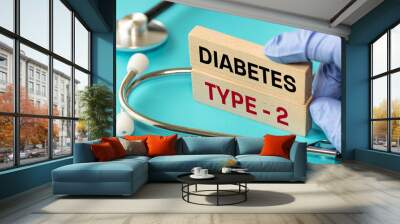 Diabetes type 2. Medical and health concept. Diabetes type 2 symbol, words on wooden blocks, stethoscope, doctor hand, Beautiful blue background Wall mural