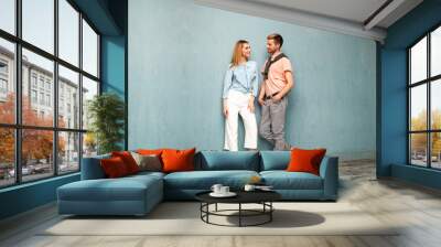 .Fashion girl and guy in outlet clothes posing on a blue background Wall mural