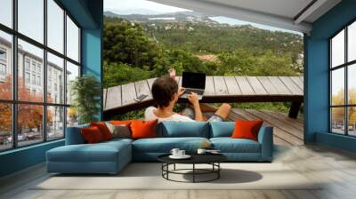 freelancer guy sits working with a view of Samui island and the mountains Wall mural