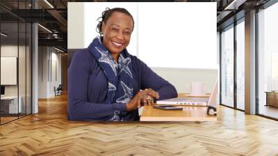 A black businesswoman poses for a portrait at her desk Wall mural