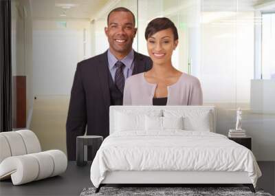 African American man and woman posing for a portrait in their office building. Black business couple holding a tablet in a corporate hallway Wall mural