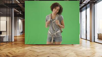 African American millennial woman wearing backpack while hiking on green screen Wall mural