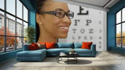 african woman trying on her new glasses Wall mural