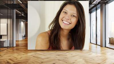 Attractive Hispanic woman playing with hair and smiling at camera Wall mural