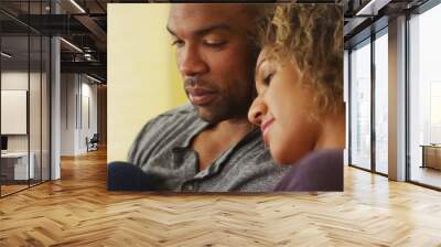 black couple sitting on couch smiling Wall mural