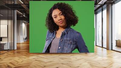 Charming young black woman in denim jacket posing on green screen Wall mural