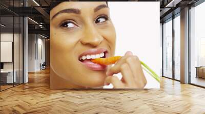 Close up of black woman eating carrot on white background Wall mural