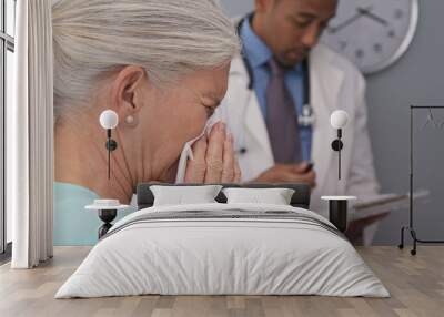 Closeup of sick elderly woman sneezing into paper tissue. Tight view of ill senior patient visiting doctors office blowing nose into tissue Wall mural