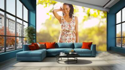 Happy black woman standing on grass Wall mural