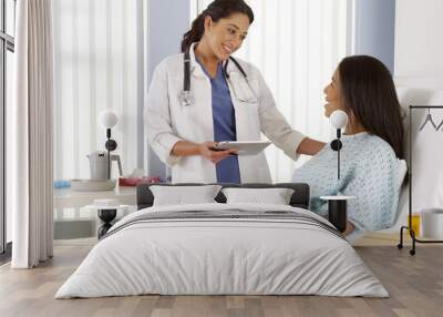 hispanic female doctor talking to african patient Wall mural