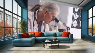 Mature white neurologist female looking at x-rays Wall mural