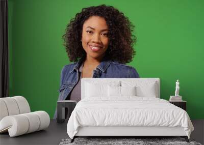 Portrait of happy black woman in jean jacket posing on green screen Wall mural