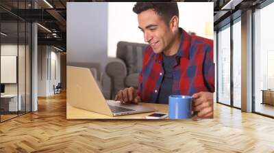 puerto rican man using laptop at desk Wall mural