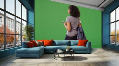 Rear view of black woman texting on smartphone on green screen Wall mural