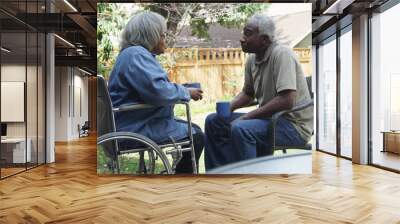 Senior African woman in wheel chair outdoors with husband Wall mural