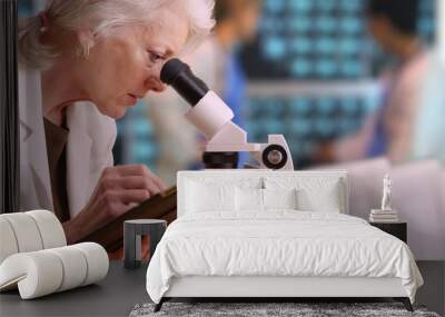 Senior woman medical researcher taking notes on tablet computer in busy lab Wall mural