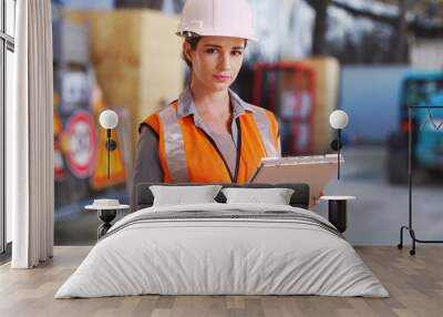 Young white lady on construction site checking things off on clipboard Wall mural