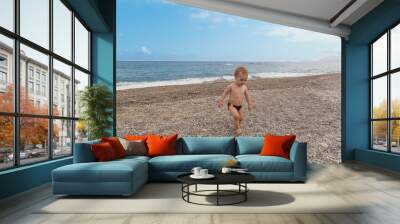 Lovely boy playing on the beach in a sunny day Wall mural