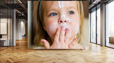 Little cute two years old girl with face cream on her cheeks, nose and forehead. Toddler testing the mother's cream at home. Child skin protection, organic cream, health and skin care Wall mural