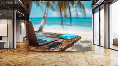 laptop on a wooden table on tropical beach - travel work concept Wall mural