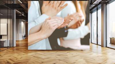 Business people clapping and applause at meeting or conference, close-up of hands. Group of unknown businessmen and women in modern white office. Success teamwork or corporate coaching concept Wall mural