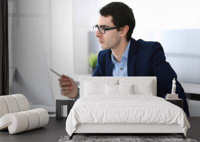 Businessman working with computer in modern office. Headshot of male entrepreneur or company manager at workplace. Business concept Wall mural