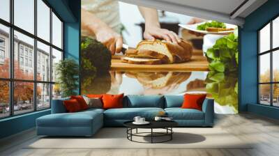 Closeup of human hands cooking in kitchen. Mother and daughter or two female friends cutting bread for dinner. Friendship, family and lifestyle concepts Wall mural