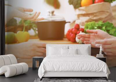 Closeup of human hands cooking in kitchen. Women discuss a menu. Healthy meal, vegetarian food and lifestyle concept Wall mural