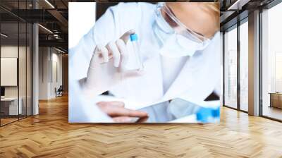 Coronavirus pandemic. Professional female scientist in protective eyeglasses researching tube in laboratory. Concepts of medicine and virus protection Wall mural