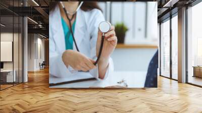 Doctor with a stethoscope in the hand. Physician is ready to examine her female patient. Wall mural