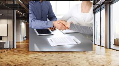 Group of business people shaking hands after discussing questions at meeting in modern office. Handshake close-up. Teamwork, partnership and agreement in business concept Wall mural