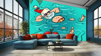 Santa Claus relaxing at a seaside resort. Man swimming in the pool. New Year and Christmas Wall mural