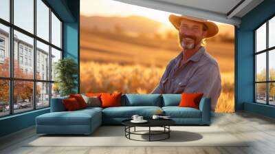 Agriculture, farming, happy man farmer standing in sunny golden wheat field with harvest at sunset Wall mural