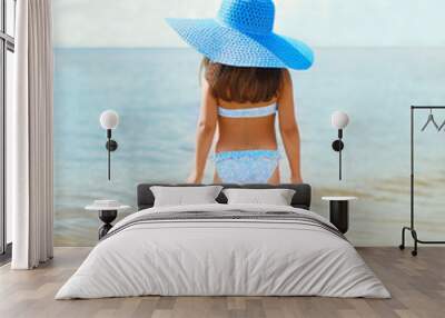 Back view of beautiful little girl child in swimsuit and straw h Wall mural