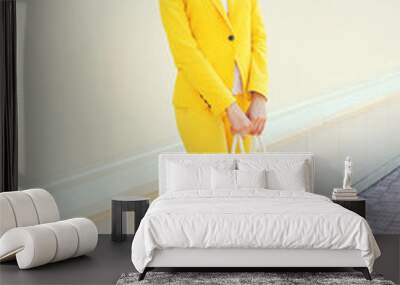 Beautiful young woman in yellow suit clothes with handbag outdoo Wall mural