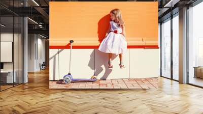 cute little girl in white dress and scooter against the urban co Wall mural